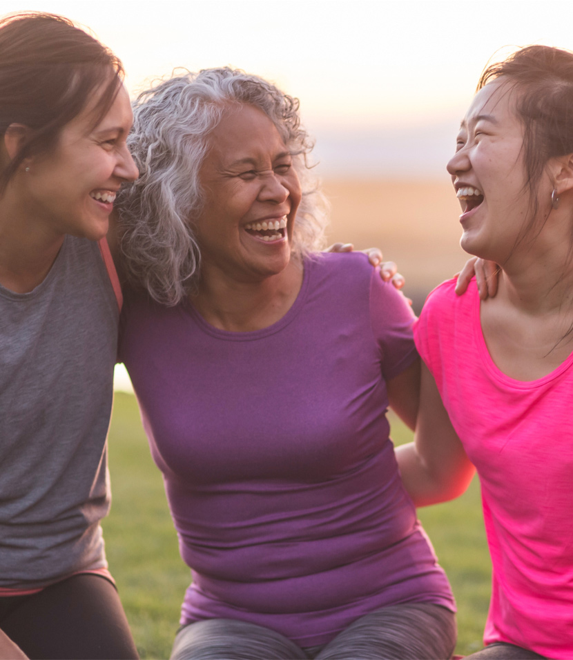 Three women young and old laughing outdoors