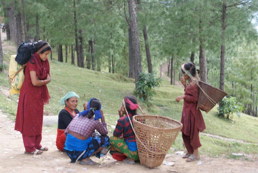 Group of Nepalese women outdoors, young and old, with large baskets